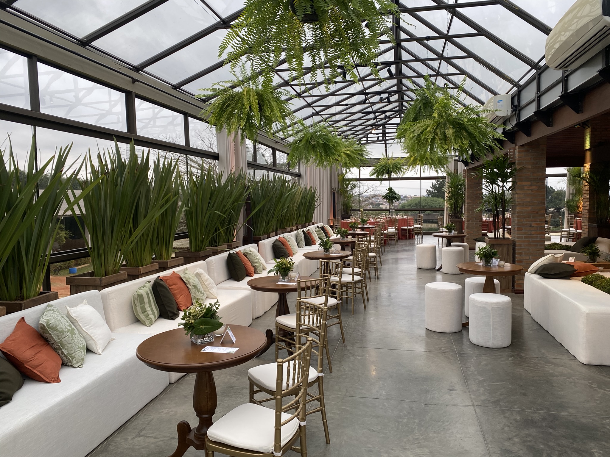 Salão Premium do Paraíso Park com lounge, plantas e teto de vidro